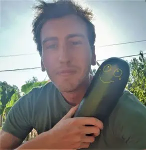 Robin, auteur van de blog, houdt een courgette uit de moestuin vast